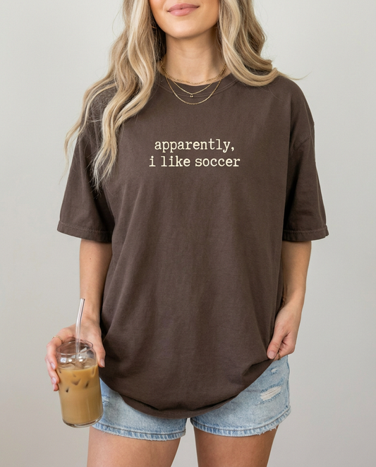 Woman wearing apparently i like soccer espresso Comfort Colors tee