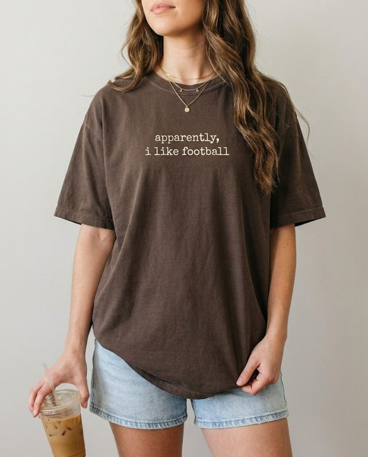 Woman wearing apparently i like football espresso Comfort Colors tee