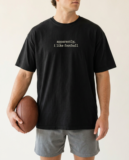 Man in black apparently i like football tee holding a football