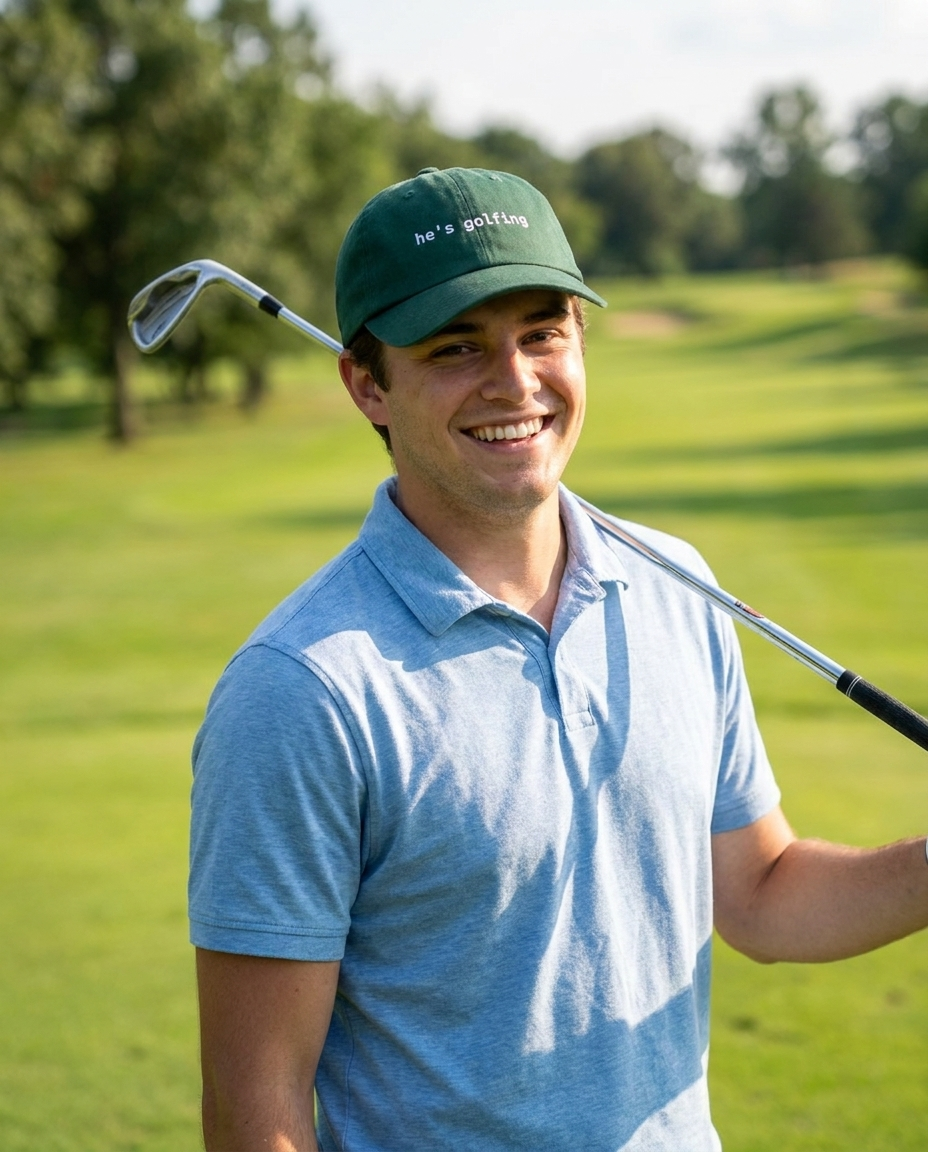 Golfer wearing the He's Golfing funny golf dad hat outdoors