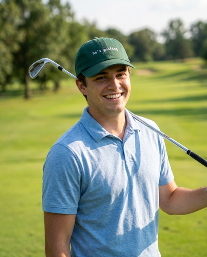 Golfer wearing the He's Golfing funny golf dad hat outdoors