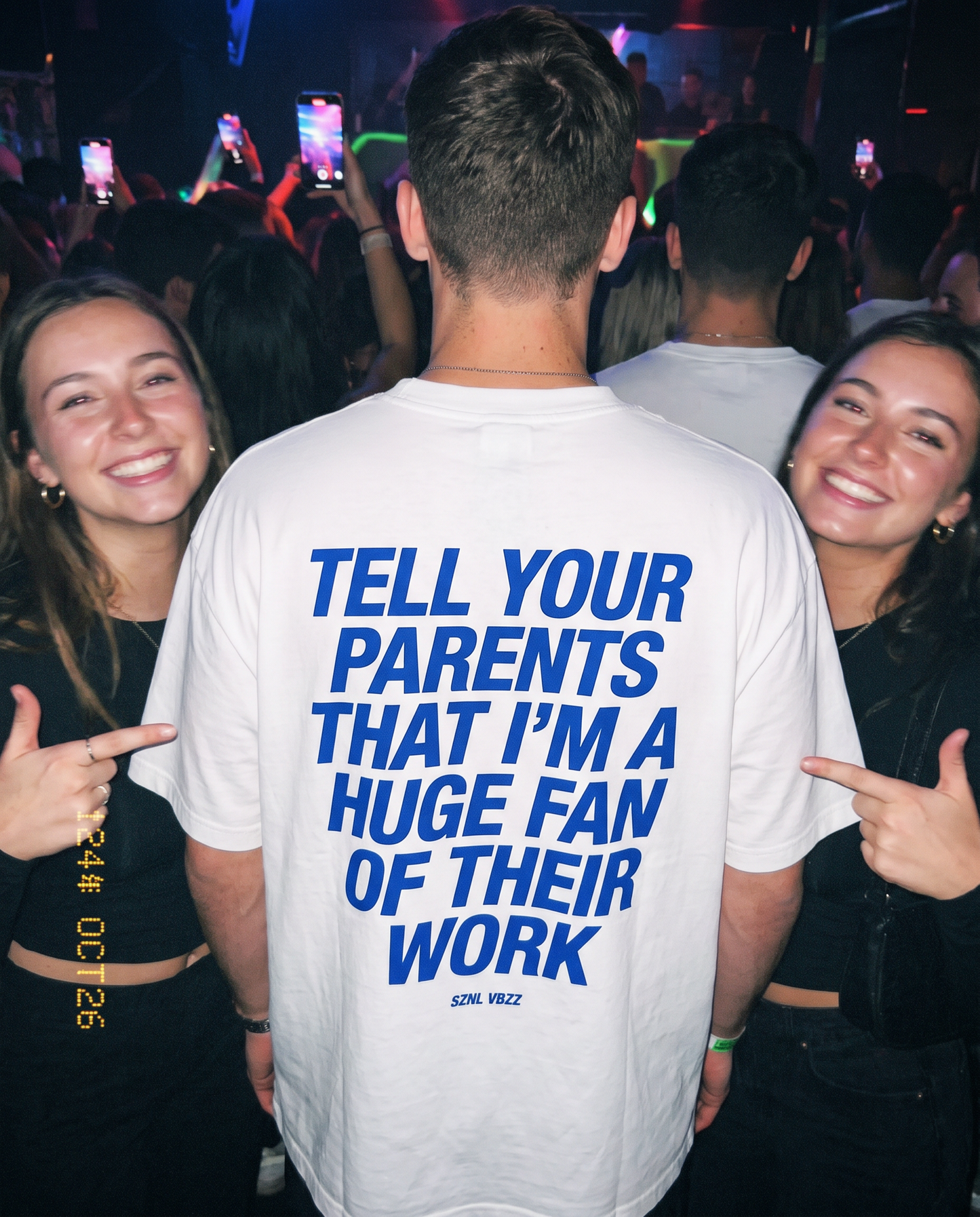 Tell Your Parents back print tee at a club, friends pointing