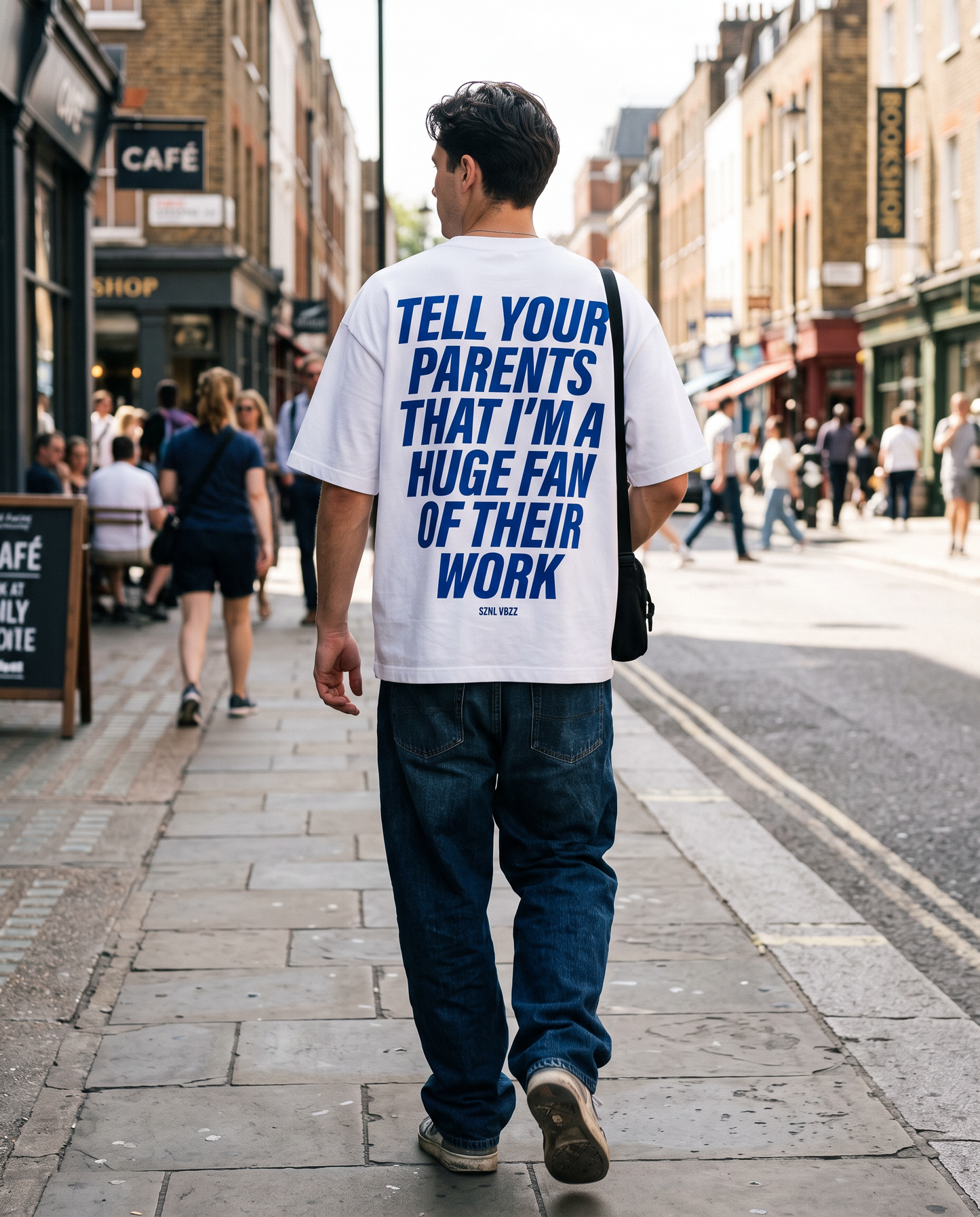 Blue back print Tell Your Parents tee worn walking down a sunlit street
