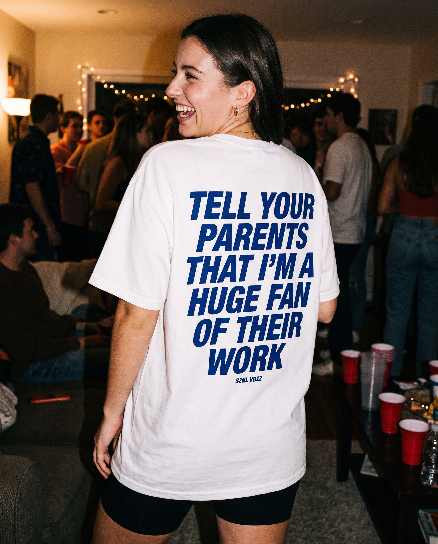 Woman wearing the oversized Tell Your Parents tee at a house party