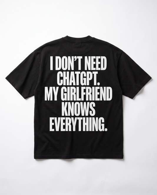I Don't Need ChatGPT tee — white back print on black heavyweight oversized tee, flat lay