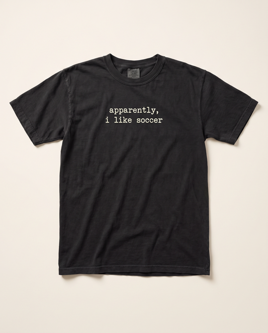 Apparently I Like Soccer tee, black flat lay