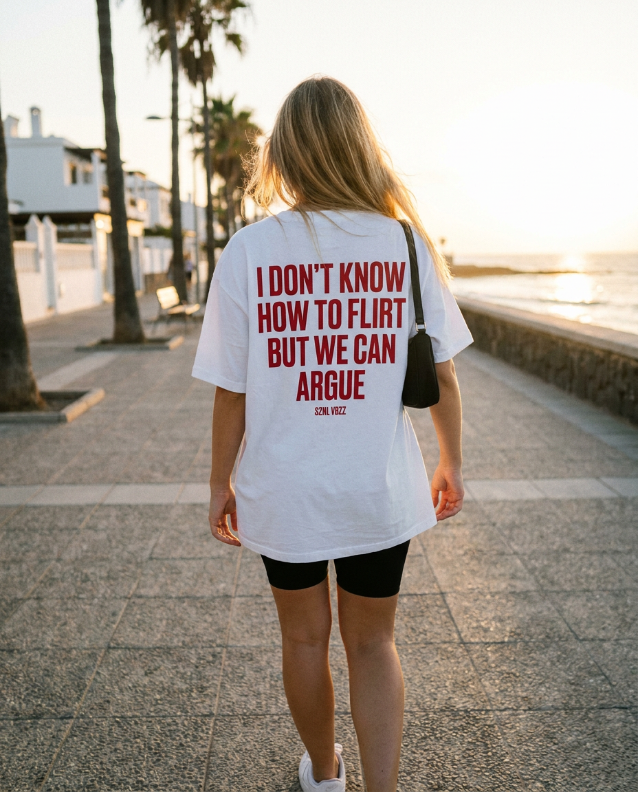 Woman wearing the white tee with red back print on a beach promenade