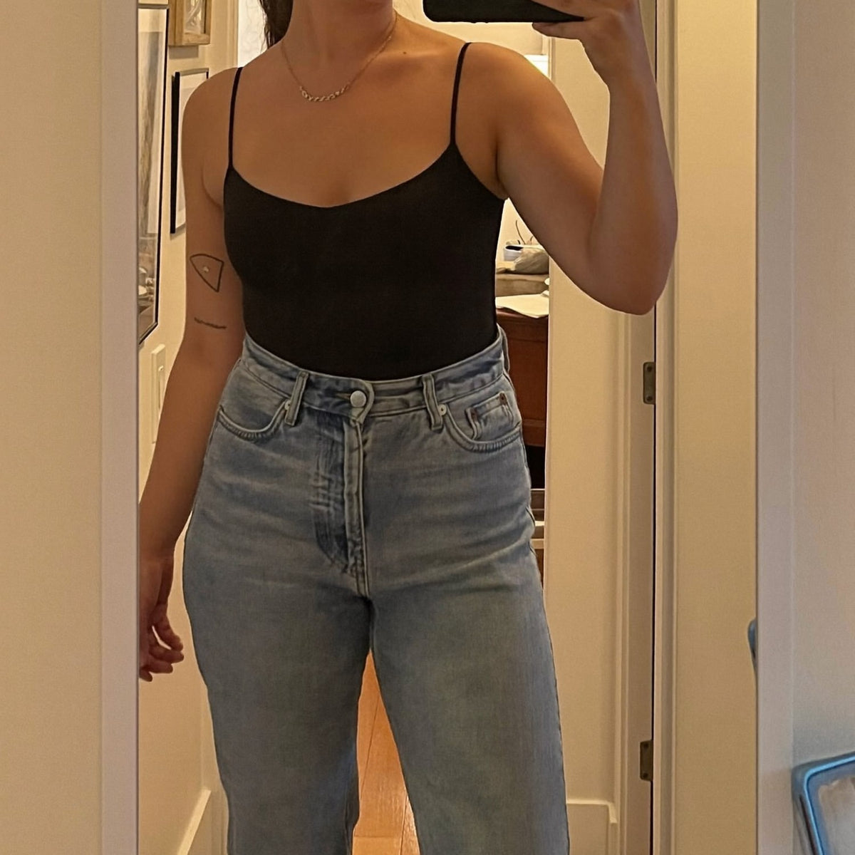 Black seamless bodysuit worn with jeans